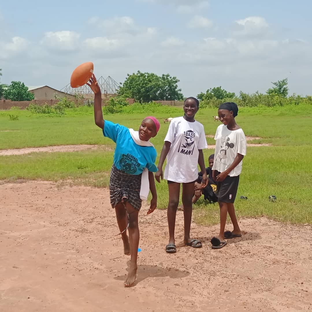 Young players practicing a football throw on a community field